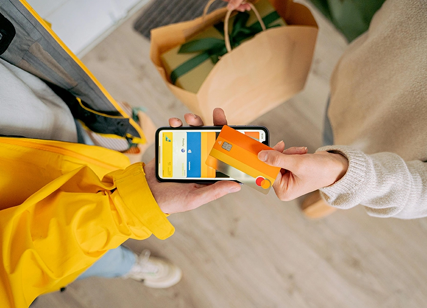 A person making a digital payment using a smartphone and credit card, representing secure online transactions and seamless checkout processes supported by ecommerce website development services.